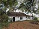 The exterior shows an old, run-down home with a damaged roof and overgrown vegetation surrounding it at 600 Powell St, Wildwood, FL 34785