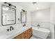 Bathroom with double sinks, standalone tub and marble tile backsplash at 657 Riverpark Cir, Longwood, FL 32779