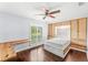 Bright bedroom with wood floors, ceiling fan, built-in desk and cabinetry at 657 Riverpark Cir, Longwood, FL 32779
