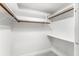 A simple reach-in closet with white walls, copper clothing rods, and white shelving at 657 Riverpark Cir, Longwood, FL 32779