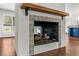 Close up of stucco fireplace with decorative tile surround, wood mantel and hearth at 657 Riverpark Cir, Longwood, FL 32779