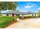 Charming one-story home featuring mature landscaping, painted brick, dark roof and a welcoming red front door at 657 Riverpark Cir, Longwood, FL 32779