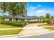 Charming one-story home featuring mature landscaping, painted brick, dark roof and a circular driveway at 657 Riverpark Cir, Longwood, FL 32779