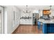 Kitchen with white cabinets, blue island, stainless steel appliances, and modern backsplash at 657 Riverpark Cir, Longwood, FL 32779