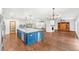 Spacious open-plan kitchen featuring a large blue island, hardwood floors and stainless steel appliances at 657 Riverpark Cir, Longwood, FL 32779