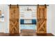 Office features barn doors, white shiplap walls, blue cabinets, and open shelving at 657 Riverpark Cir, Longwood, FL 32779
