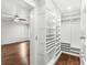 A walk-in closet featuring custom white built-in shelving and hardwood floors at 657 Riverpark Cir, Longwood, FL 32779