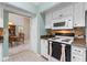 Bright kitchen with white appliances and cabinets and tile floors, open to the dining area at 6608 Borg, Leesburg, FL 34748