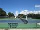 Enjoy a game of tennis on this court secured by a fence, set against a blue sky and lush foliage at 6608 Borg, Leesburg, FL 34748