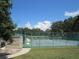 Enjoy a game of tennis on this court secured by a fence, set against a blue sky and lush foliage at 6608 Borg, Leesburg, FL 34748