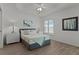 Well-lit bedroom with tray ceiling, wood floors, and a window with shutter, offering a peaceful retreat at 7382 Se 167Th Zina Ln, The Villages, FL 32162