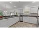 Modern kitchen featuring stainless steel appliances, white cabinets, and an adjacent breakfast bar at 7382 Se 167Th Zina Ln, The Villages, FL 32162
