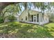 A spacious backyard has green grass, a tree with Spanish Moss, and a sunroom with large windows at 791 Wolf Creek St, Clermont, FL 34711