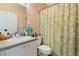 The bathroom shows a vanity with white sink, toilet, and leaf-patterned shower curtain at 791 Wolf Creek St, Clermont, FL 34711