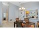 Elegant dining area with a wood table, four chairs, and a view through the cut out into the kitchen area at 791 Wolf Creek St, Clermont, FL 34711