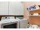 Laundry room with white washer and dryer and white shelving at 791 Wolf Creek St, Clermont, FL 34711