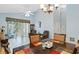 Open-concept dining and living area with tile floors, ceiling fans, neutral paint, and a sliding door to the outside at 791 Wolf Creek St, Clermont, FL 34711