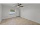 Bedroom boasting tiled floors, neutral walls, a ceiling fan, and a window to the backyard at 8158 Bucksaw Dr, Orlando, FL 32817