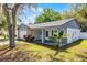 Single Gathering home boasting a covered front porch, mature trees, and stone accents at 8158 Bucksaw Dr, Orlando, FL 32817
