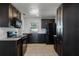 Galley kitchen featuring dark cabinets, stainless appliances, and a window over the sink at 8158 Bucksaw Dr, Orlando, FL 32817
