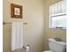 Neutral bathroom with a comfort height toilet, decorative mirror, and towel bar at 830 Grand Vista Trl, Leesburg, FL 34748