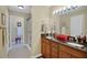 Bathroom featuring double sinks, granite countertops, and a tiled shower for a luxurious feel at 830 Grand Vista Trl, Leesburg, FL 34748