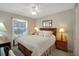 Well-lit bedroom featuring a comfortable bed, side tables, and a window with sheer curtains at 830 Grand Vista Trl, Leesburg, FL 34748