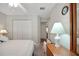 Neutral bedroom with a closet, light walls, and a mirror above a wooden side table at 830 Grand Vista Trl, Leesburg, FL 34748