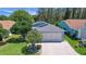 Charming single-story home with an attached two-car garage and well-maintained landscaping at 830 Grand Vista Trl, Leesburg, FL 34748