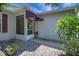 Inviting front porch with a screened entrance, awning, and beautiful landscaping at 830 Grand Vista Trl, Leesburg, FL 34748