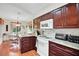 Well-equipped kitchen with rich wood cabinetry, granite countertops, and modern appliances at 830 Grand Vista Trl, Leesburg, FL 34748
