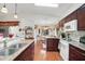 Open-concept kitchen with granite countertops and wood cabinets overlooking the dining area at 830 Grand Vista Trl, Leesburg, FL 34748