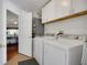 Bright laundry room featuring white cabinets and modern washer and dryer appliances at 830 Grand Vista Trl, Leesburg, FL 34748