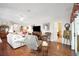 Spacious living room with hardwood floors, comfortable seating, and a large TV for entertainment at 830 Grand Vista Trl, Leesburg, FL 34748