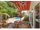 Inviting covered patio with seating area overlooking a sparkling pool and lush tropical landscaping at 910 Locust St, New Smyrna Beach, FL 32169