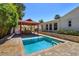 Beautiful backyard oasis featuring a refreshing pool, cabana, and well-manicured landscaping at 910 Locust St, New Smyrna Beach, FL 32169