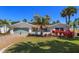 Charming single-story home with a well-manicured lawn, colorful plants, and a serene tropical ambiance at 910 Locust St, New Smyrna Beach, FL 32169