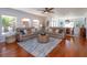 Cozy living room with plush sectional sofa, wood floors, and bright natural light at 910 Locust St, New Smyrna Beach, FL 32169