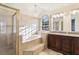 Elegant bathroom features a glass enclosed shower and tub, chandelier, and vanity at 981 Piedmont Oaks Dr, Apopka, FL 32703