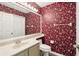 Bathroom with bold floral wallpaper, single vanity, and a large mirror at 981 Piedmont Oaks Dr, Apopka, FL 32703