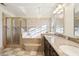 Elegant bathroom features a glass enclosed shower and tub, chandelier, and double vanity at 981 Piedmont Oaks Dr, Apopka, FL 32703