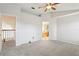 Bright bedroom featuring a ceiling fan and neutral decor, showing access to bathroom and stairs at 981 Piedmont Oaks Dr, Apopka, FL 32703