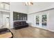 Bright living room with french doors, hardwood floors, a dark leather sofa and a high ceiling at 981 Piedmont Oaks Dr, Apopka, FL 32703