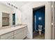 Bathroom featuring a vanity, toilet, walk in shower with blue accent wall, and access to the walk in closet at 992 Pinewood Pl, The Villages, FL 32162