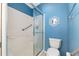 Bathroom with a toilet and shower featuring a sliding glass door and grab bar for safety at 992 Pinewood Pl, The Villages, FL 32162