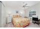 Bright bedroom showcasing a ceiling fan, comfortable bed, desk and closet space at 992 Pinewood Pl, The Villages, FL 32162
