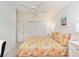 Comfortable bedroom with a closet featuring sliding doors and a ceiling fan, complemented by neutral walls at 992 Pinewood Pl, The Villages, FL 32162