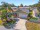 Charming home featuring a well-manicured lawn, decorative shrubs, and a two-car garage at 992 Pinewood Pl, The Villages, FL 32162