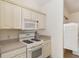 Practical kitchen features a gas range, microwave, and white cabinetry at 992 Pinewood Pl, The Villages, FL 32162