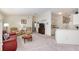 Bright and airy living room with comfortable seating, a ceiling fan, and an open layout leading into the kitchen at 992 Pinewood Pl, The Villages, FL 32162